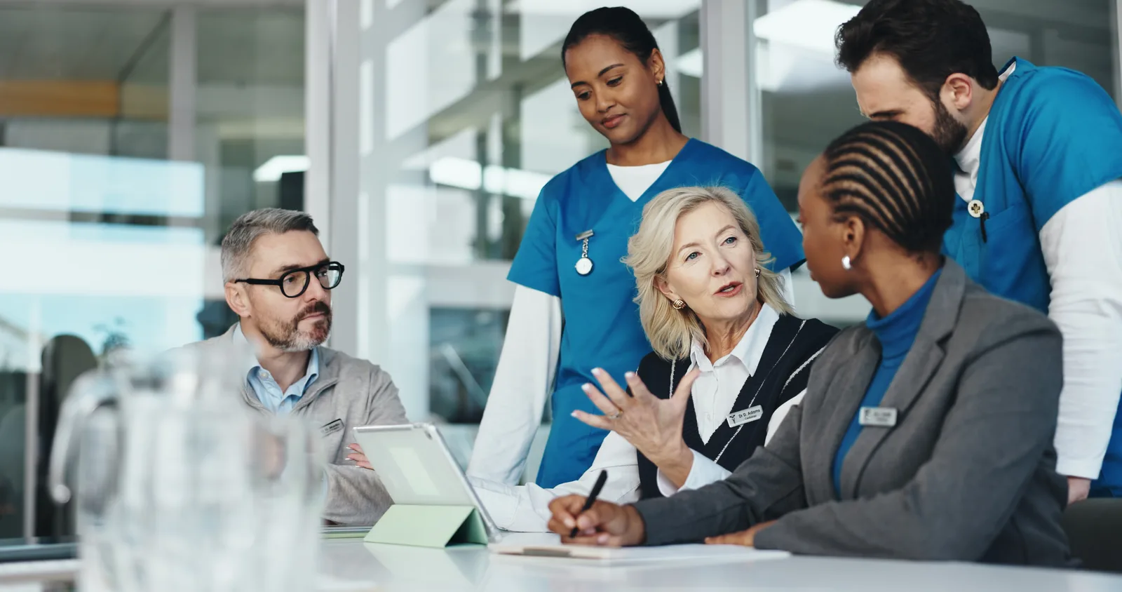 Healthcare leaders in conversation with clinical staff in a hospital